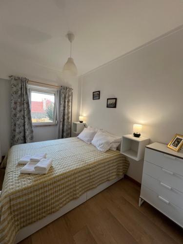 een witte slaapkamer met een bed en een raam bij Apartamento Vasco da Gama in Lissabon