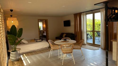 un soggiorno con letto, tavolo e sedie di ULU House With Terrace & Hot Tub a Mārupe