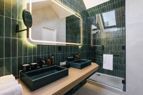 een badkamer met 2 groene wastafels en een spiegel bij Bio-Hotel Schani Wienblick in Wenen