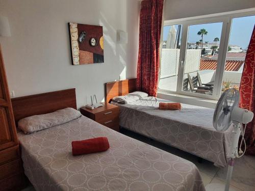 una camera d'albergo con due letti e una finestra di Island Village ad Adeje