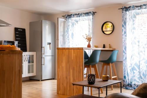 a kitchen with a refrigerator and a table at Appartement au Centre ville historique Le vieux Langres in Langres