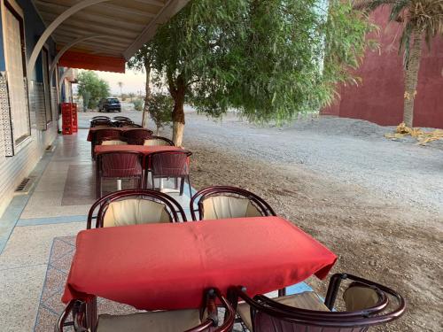 a row of red tables and chairs on a sidewalk at AMRAOUI Apartment in Rissani