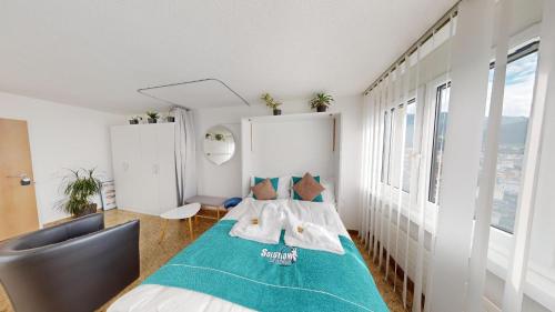 Un dormitorio con una cama con una manta azul. en Über den Dächer von Chur (Dreibündenstein) en Chur