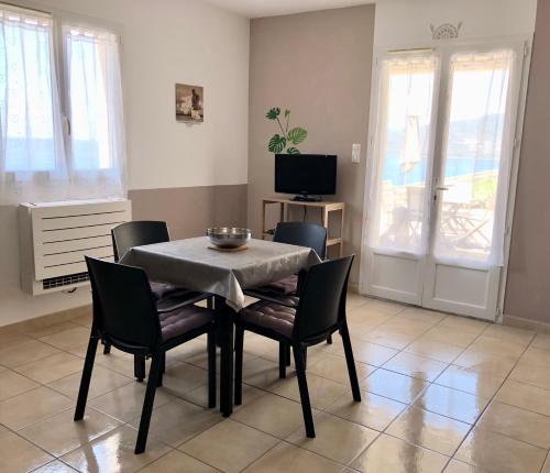 une salle à manger avec une table, des chaises et une télévision dans l'établissement L'armandulina, à Sagone
