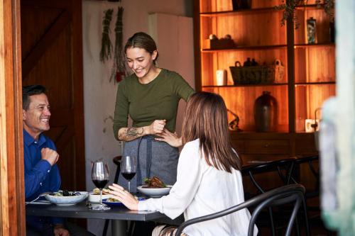 a woman standing in front of a table with a man at Vergenoegd Löw Boutique Hotel & Spa in Cape Town
