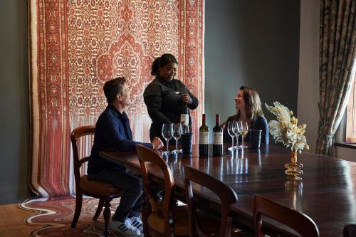 a group of people sitting around a table with wine glasses at Vergenoegd Löw Boutique Hotel & Spa in Cape Town