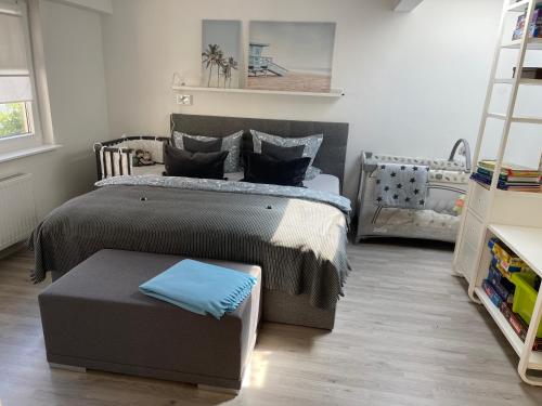 1 dormitorio con cama y reposapiés en Ostsee Ferienwohnung Möwengasse, en Travemünde