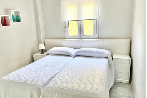 Cama blanca en habitación blanca con ventana en MARBELLA - ALICATE BEACHFRONT Apartment-8 en Marbella