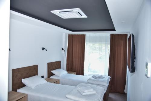 a hotel room with two beds and a window at Apartmani COLOSSEUM in Bratunac