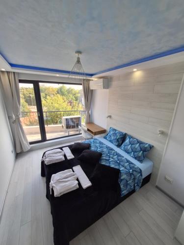una camera con un grande letto e una grande finestra di Cloud 6 -Top Center,360° view,Free private parking a Plovdiv