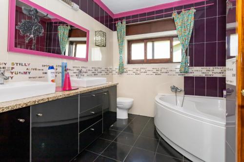 a bathroom with a tub and a sink and a toilet at The whole villa, near a large park and a quiet beach in Barreiro