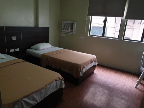 a hotel room with two beds and a window at OYO 1011 First Hotel in Manila
