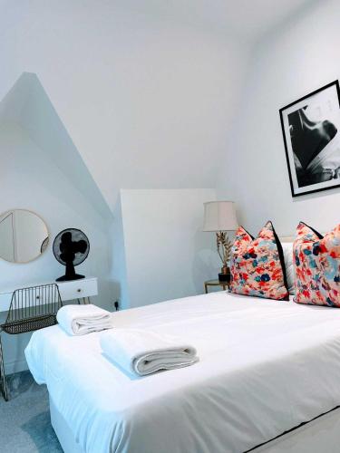 a bedroom with a bed with white sheets and pillows at Cardiff luxury apartment in Cardiff