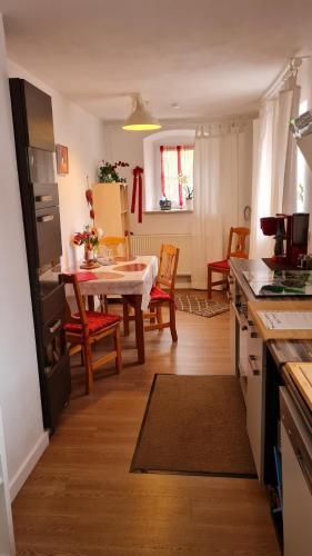 eine Küche und ein Esszimmer mit Tisch und Stühlen in der Unterkunft Ferienwohnung Itzgrundruhe in Untermerzbach