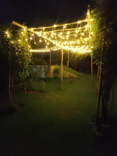 a lit up pergola with lights on it at night at Private room in Retreat by Walias Farm Stay in Sohna