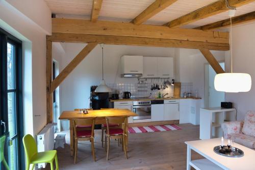 uma cozinha e sala de jantar com uma mesa de madeira e cadeiras em Gutshof Langensee em Langensee