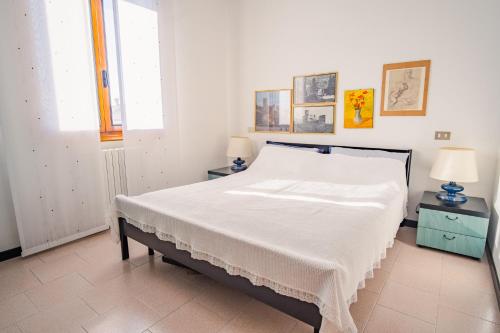 1 dormitorio con 1 cama blanca grande y 2 lámparas en Smiling Apartment - Italian Homing, en Sirmione