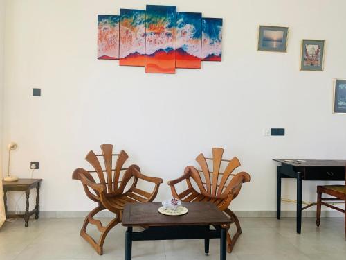 a room with chairs and a table and a piano at Kavin Beach Hotel Hikkaduwa in Hikkaduwa
