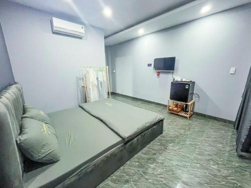 River Hotel 4 Long Xuyên في لونج زوين: غرفة نوم صغيرة بها سرير وتلفزيون