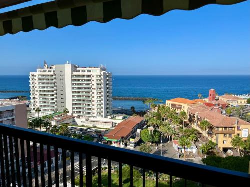 a balcony with a view of a city and the ocean at Lookout Point Tenerife Holiday Apartment Las Americas in Playa Fañabe
