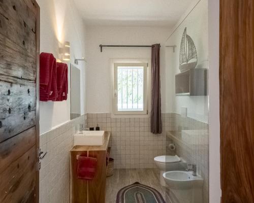a bathroom with a sink and a toilet and a window at Ocean Blue Apartment with Panoramic Pool ZanzibarHouses in Kiwengwa