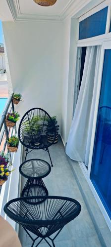 a balcony with three black chairs and a window at Nyali Vista in Mombasa