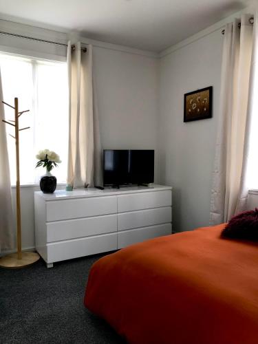 a bedroom with a bed and a television on a dresser at Santos Place in Auckland