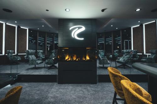 a dressing room with a fireplace and chairs and a sign at SKI - GOLF - WELLNESS Hotel Riml in Hochgurgl