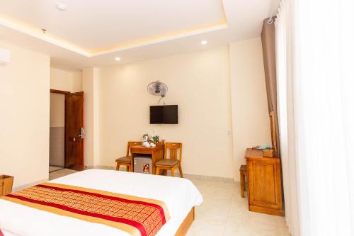 a bedroom with a bed and a tv on the wall at Dong Do Airport Hotel in Ho Chi Minh City