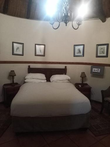 een slaapkamer met een groot bed met 2 kussens bij Harties Lodge - Private Suite in Hartbeespoort