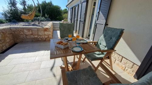 a wooden table and chairs on a patio at Apartmani STJEPAN in Zavala