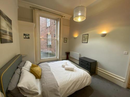 sypialnia z łóżkiem i oknem w obiekcie MMR Flats w mieście Carlisle