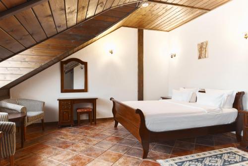 a bedroom with a bed and a chair and a table at Chateau Purcari in Purcari