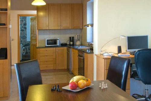 a kitchen with a table with a plate of fruit on it at Petrini Krini Luxury Appartments in Ypsilométopon