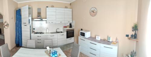 a kitchen with white cabinets and a sink at "La ca` 'd Giaculin" -Casetta indipendente in Magliano Alpi