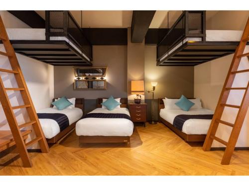 - une chambre avec 3 lits superposés et une chambre avec des escaliers dans l'établissement GoodDay Hotel - Vacation STAY 84248, à Chatan