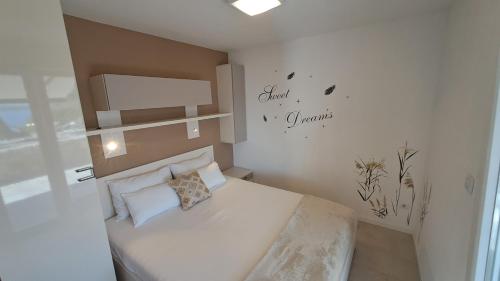a small bedroom with a bed and a sign on the wall at Apartmani STJEPAN in Zavala