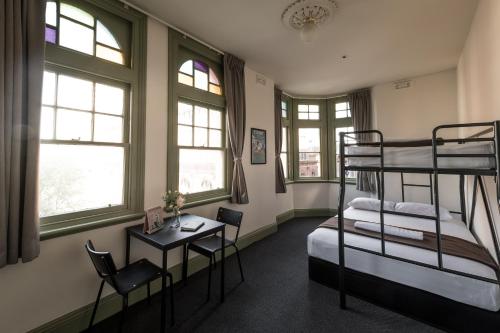 a room with two bunk beds and a desk at Sydney Central Inn in Sydney