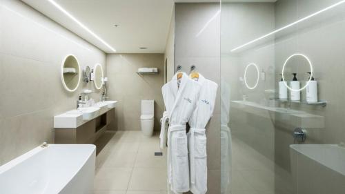 a bathroom with white towels hanging on a wall at Pacific Hotel Cairns in Cairns