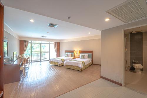 a hotel room with two beds and a bathroom at Eco Hotel by Thammasat in Bang Lamung