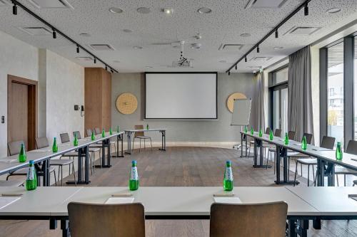 a conference room with tables and chairs and a whiteboard at GRANO HOTEL Solmarina in Wiślinka