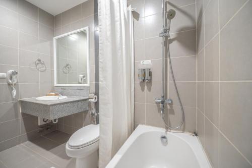 a bathroom with a toilet and a sink and a shower at Eco Hotel by Thammasat in Bang Lamung