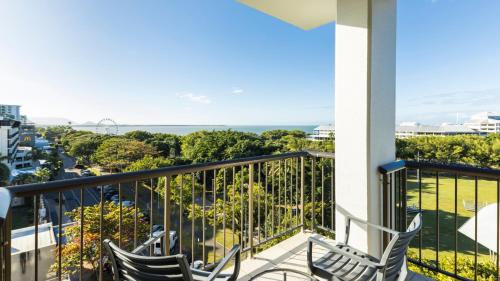 two chairs sitting on a balcony looking out at the ocean at Pacific Hotel Cairns in Cairns