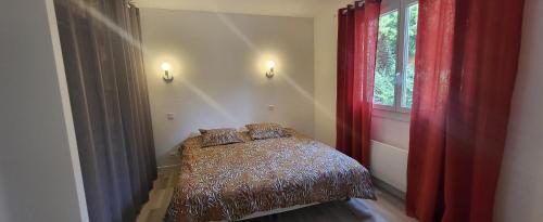 a bedroom with a bed and a window with red curtains at L'Ecrin des Alpilles in Graveson
