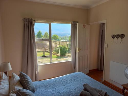 a bedroom with a bed and a large window at Twogether self catering in Clarens