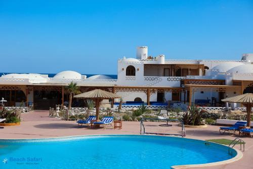 un complexe avec une piscine en face d'un bâtiment dans l'établissement Beach safari nubian resort, à Marsa Alam