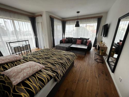 - un salon avec un lit et un canapé dans l'établissement Apartman Champion III, à Plzeň