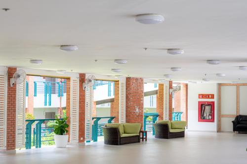 a room with chairs and tables in a building at Eco Hotel by Thammasat in Bang Lamung