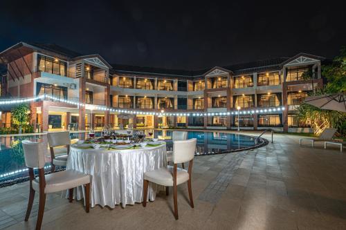 a hotel with a table and chairs in front of a pool at Eco Hotel by Thammasat in Bang Lamung