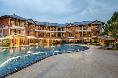 un hotel con piscina frente a un edificio en Eco Hotel by Thammasat en Bang Lamung